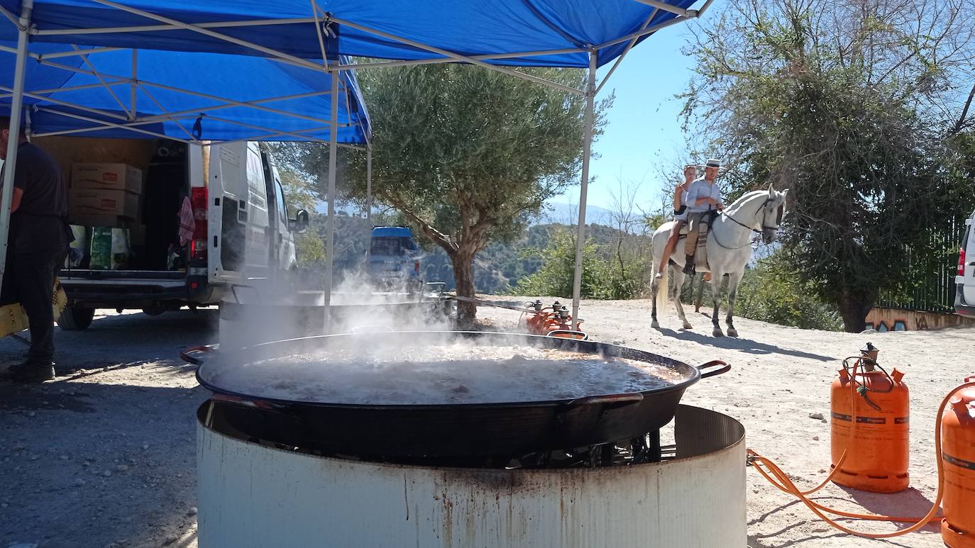 Imagen principal - Una de las dos paelleras donde se preparó el arroz para mil personas a tres euros el plato. Mientras, la gente trasegaba cervezas o hacía cola para comprar los tiques.