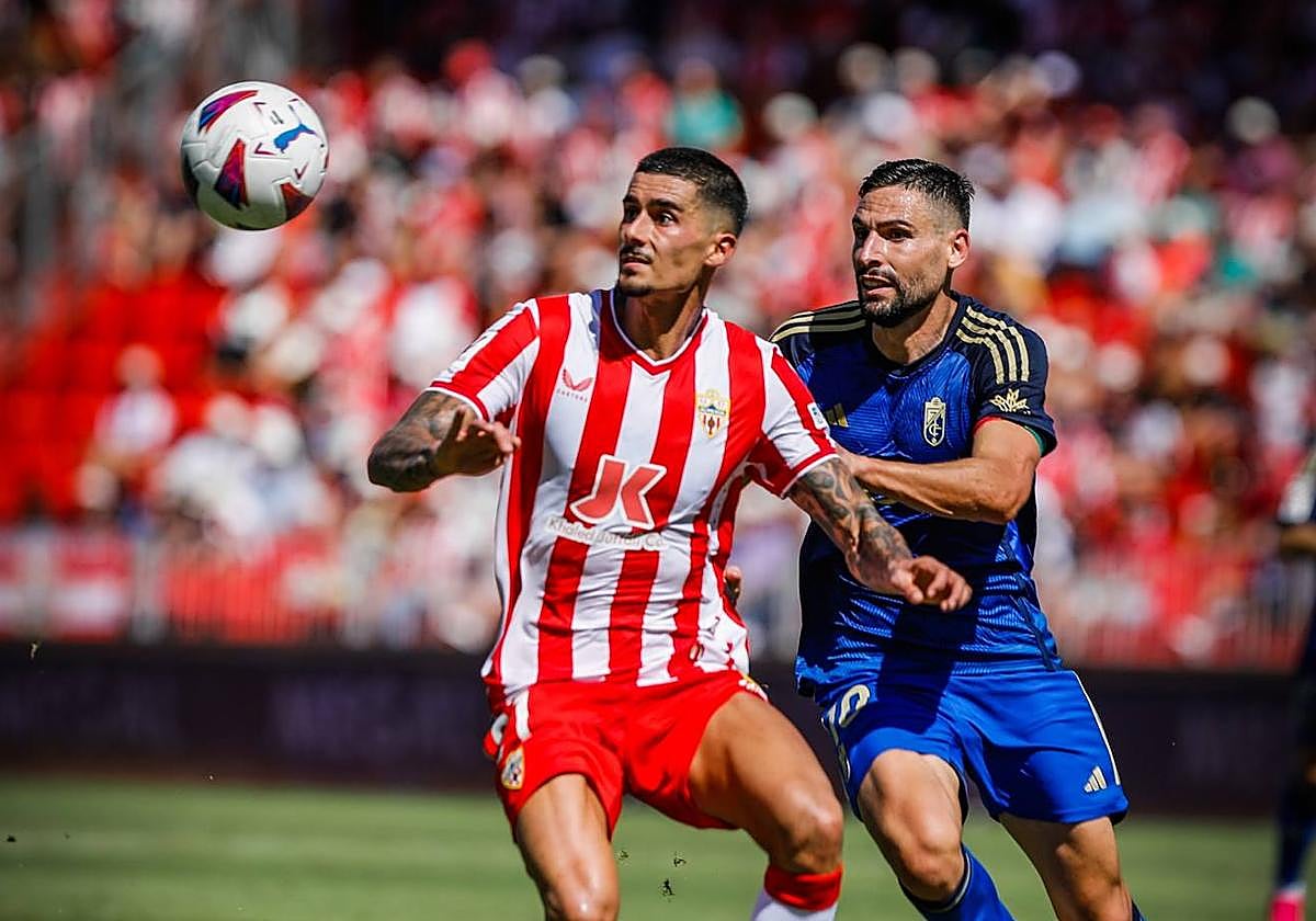 Chumi busca el balón con la mirada, acosado por Antonio Puertas.