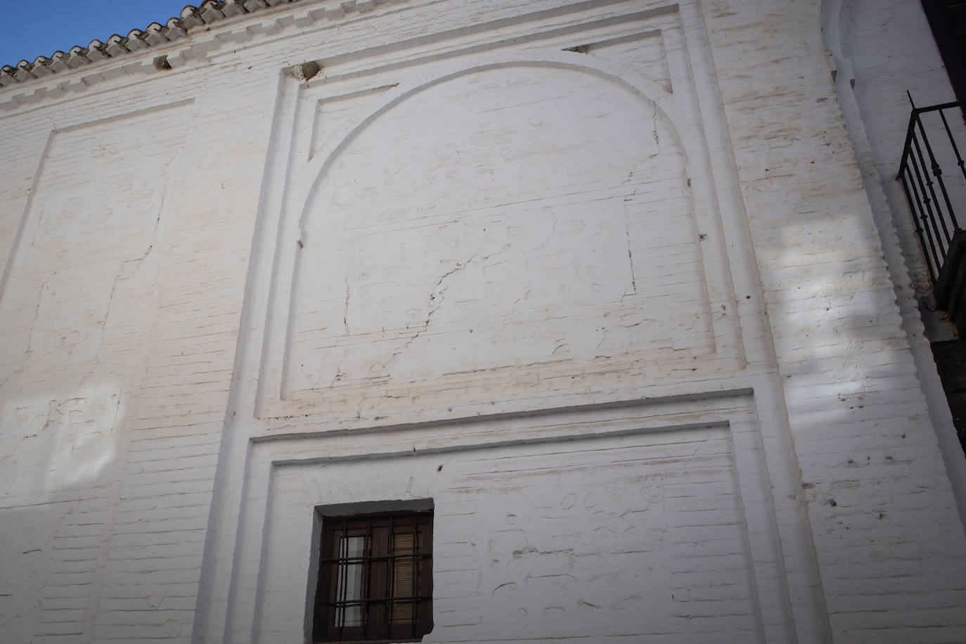 Imagen secundaria 1 - Arriba, el alcalde de Santa Fe, Juan Cano, señala la grieta en la Puerta de Sevilla. Abajo, más grietas en la Puerta de Sevilla y en una vivienda del casco histórico santaferino. 