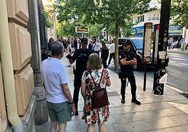 Un policía indica que no se puede pasar mientras algunos invitados de la cumbre salen de sus coches.