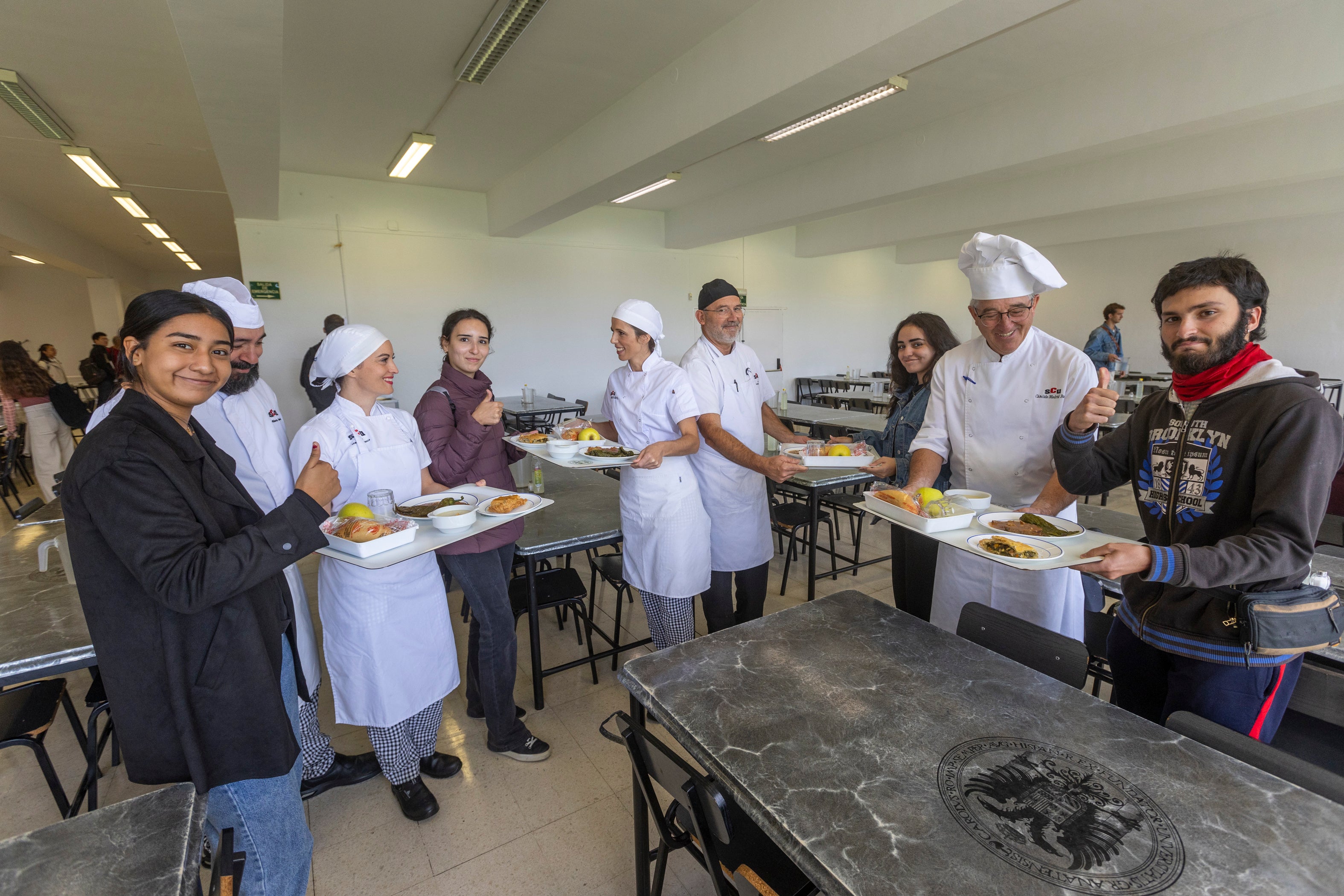 Trabajadores del comedor y usuarios universitarios en el comedor de Fuentenueva.