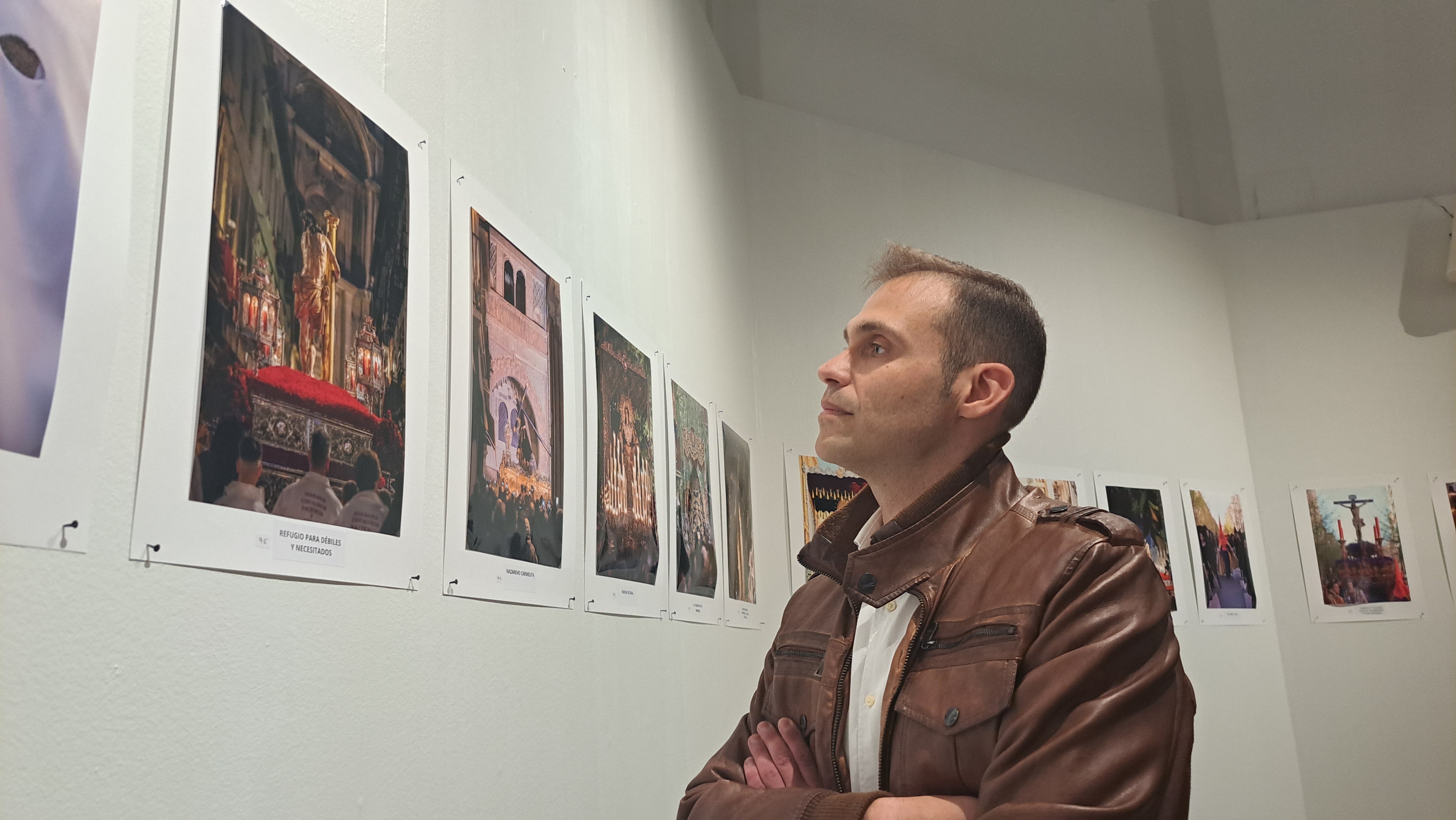 El ganador observa la fotografía elegida para el cartel.