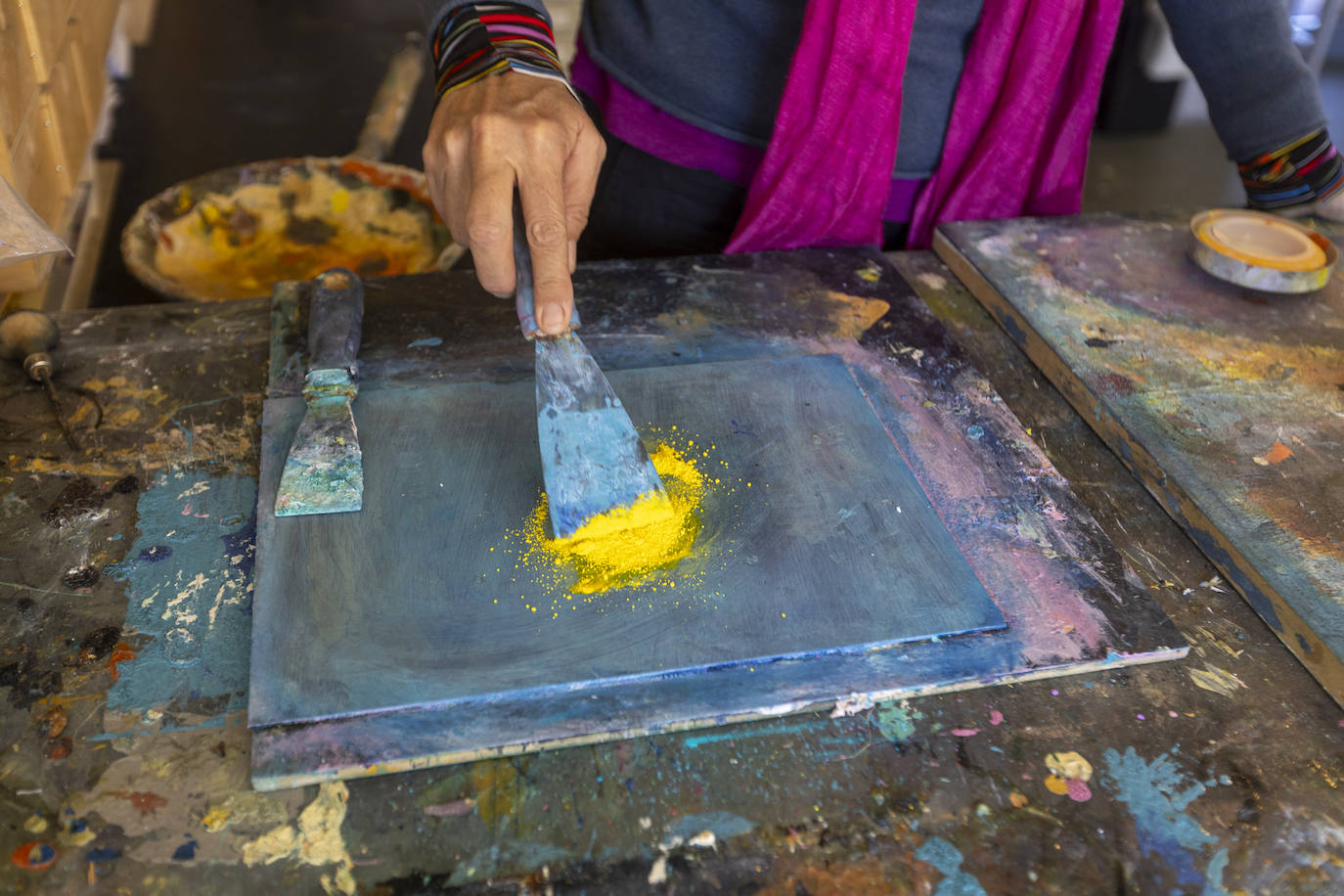 La artista extiende pigmento amarillo que luego aglutina con aceite de linaza.