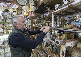 Miguel López Mariscal monta sus piezas de belén en los estantes de su tienda de la Alcaicería.