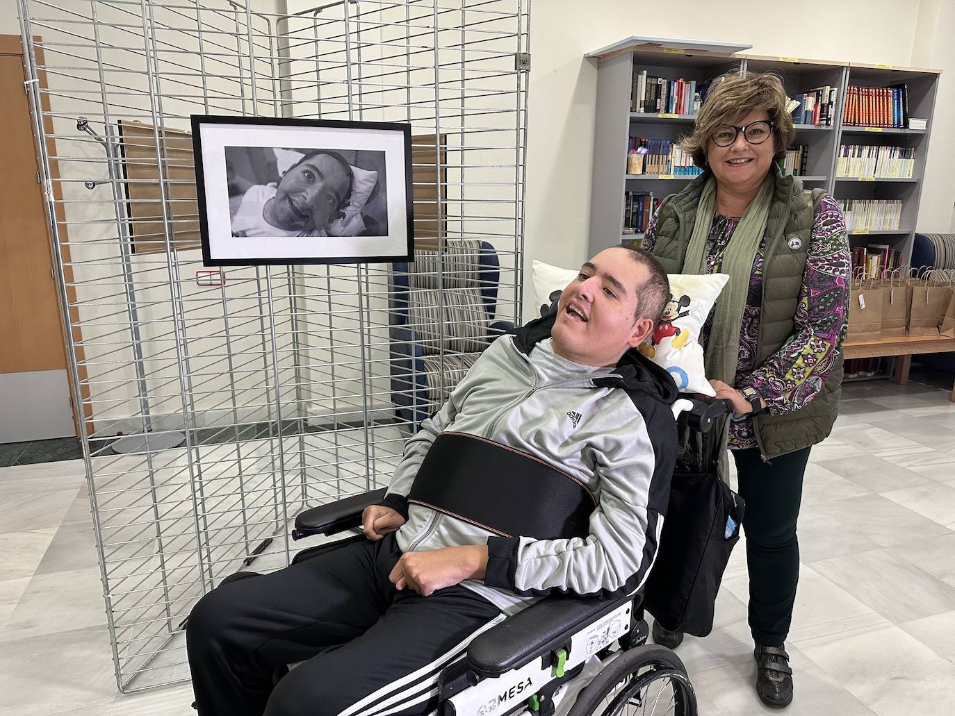 Uno de los usuarios de la residencia de FAAM, ante su propio retrato en la exposición.