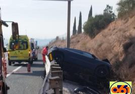 El coche volcado tras la salida de vía.