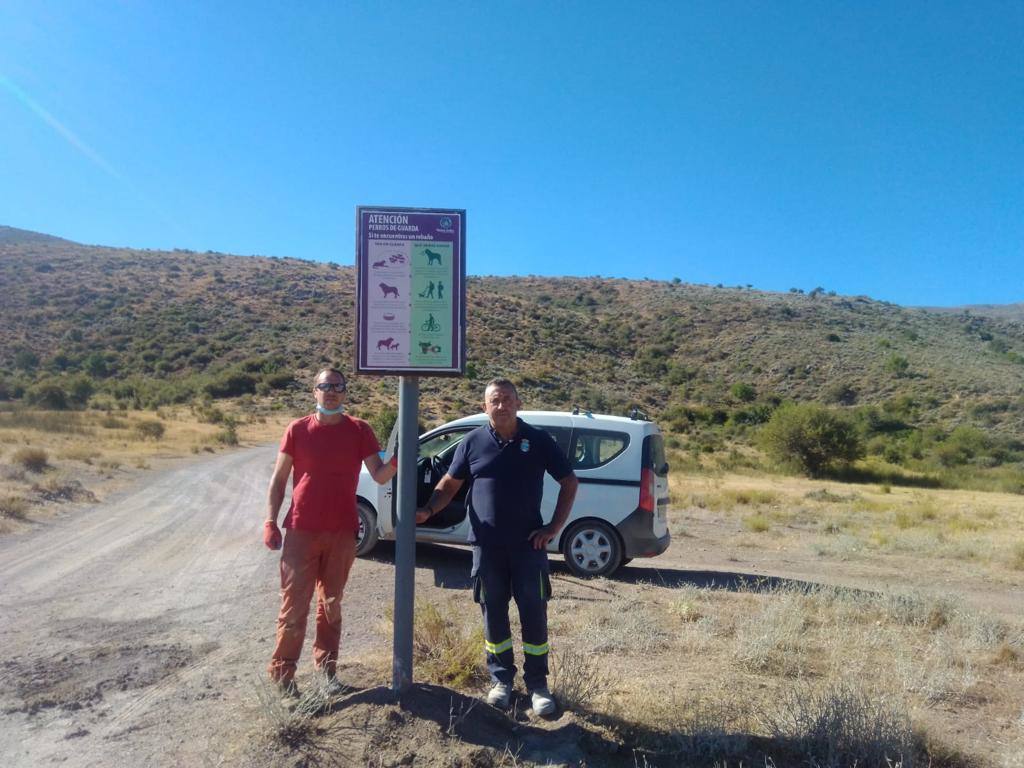 Imagen secundaria 1 - Un senderista observa la señal en Monachil en el inicio del Camino de la Umbría. Empleados municipales de Güéjar Sierra colocan el aviso en Padules. Señalización en Quéntar.