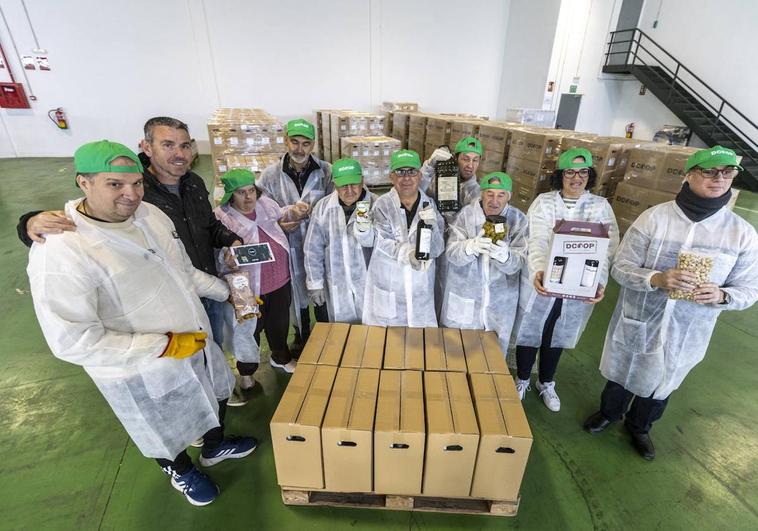 El equiop de ocho personas con discapacidad intelectual con dos de sus monitores, en la nave donde preparan las cestas navideñas.