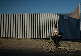 Un trabajador del campo monta en bicicleta entre invernaderos en El Ejido