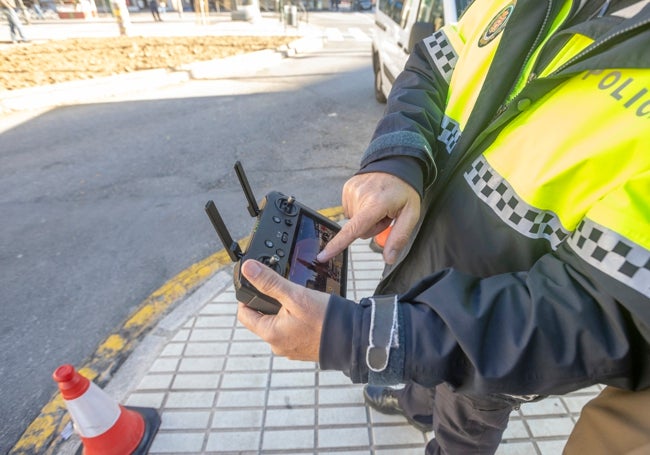 El agente muestra la pantalla y el mando con el que controla al dron.