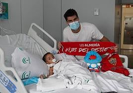 Gonzalo Melero al lado de un pequeño paciente ingresado en el Hospital Torrecárdenas.