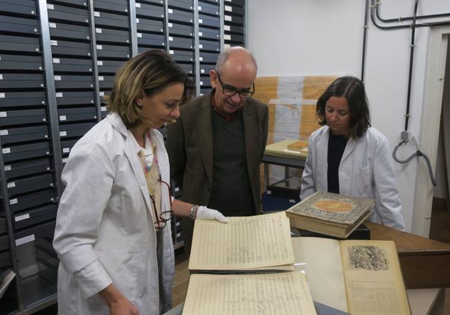 Aurora Fernández, Paolo Pinamonti y Candela Tormo, con la partitura de 'El retablo', en la cámara acorazada del Archivo Falla.