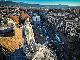 Imagen de la escultura de Isabel la Católica donde se observan sus dimensiones reales, 4,5 metros de alto, con la Acera del Darro y Sierra Nevada en planos posteriores.