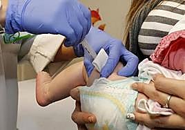 Un sanitario vacuna a un bebé.