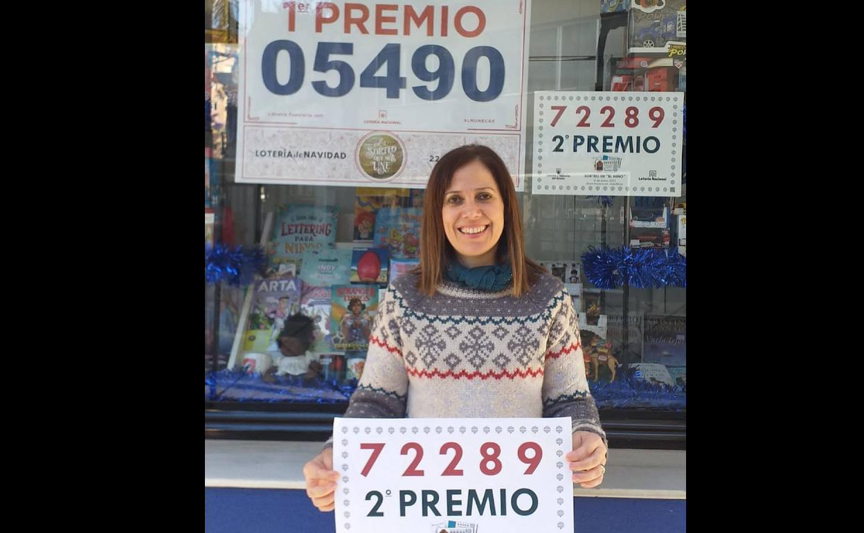 María Teresa, de la Papelería Jofi, posa con el cartel que anuncia que han dado un segundo premio de El Niño.