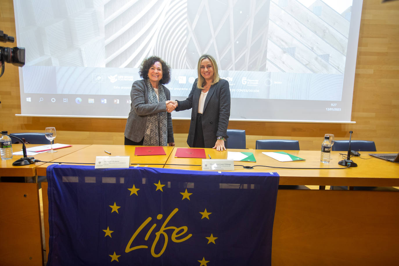 Pilar Aranda (izq.) y Marifrán Carazo estrechan sus manos tras la firma.