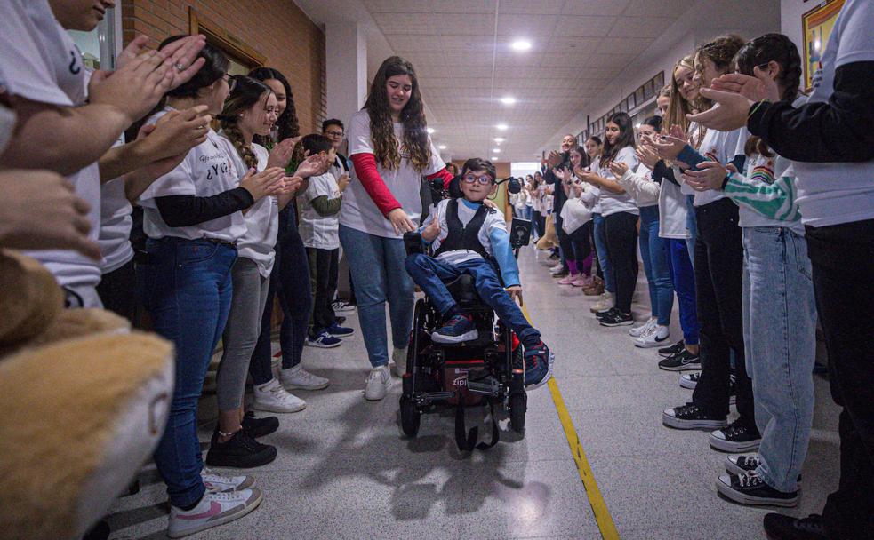 Voluntarios y voluntarias de 'La ola de los valientes' hacen el paseíllo a Martín en el instituto Arjé de Chauchina. 