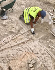 Imagen secundaria 2 - Arriba, en plena faena. Abajo, foto de familia del equipo arqueológico y excavación en uno de los edificios. 