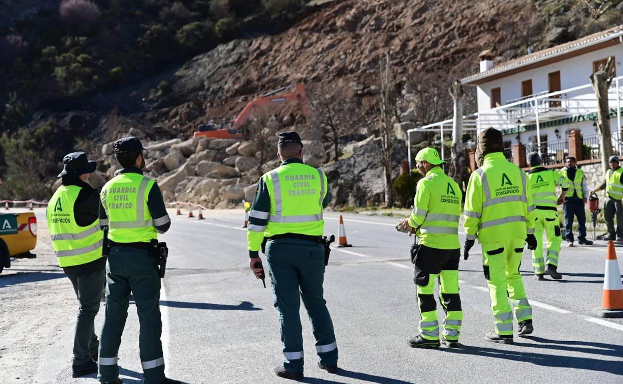 Trabajadores en la ladera junto a la Guardia Civil. 