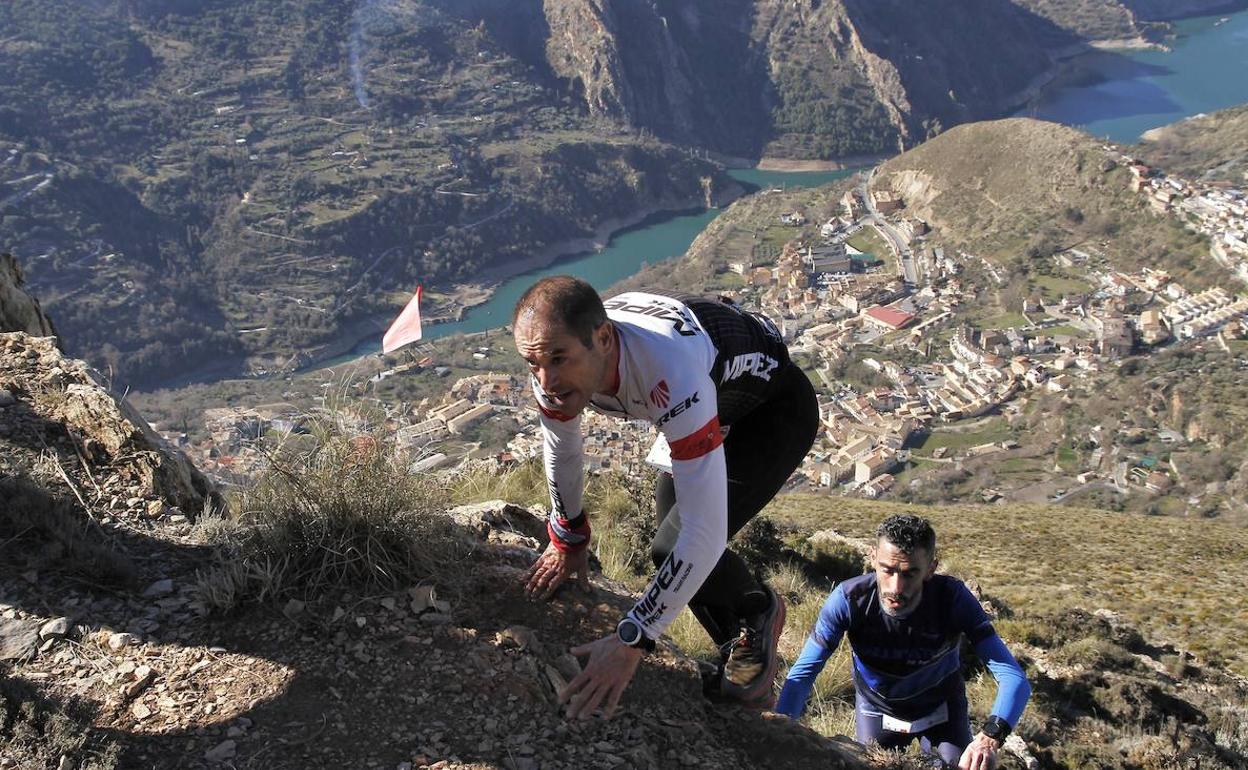 Dos participantes 'trepan' por el recorrido con el núcleo urbano de Güéjar Sierra a sus pies.