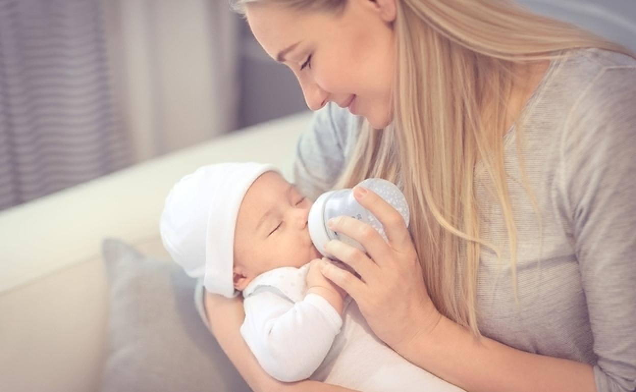 Una madre da leche de fórmula a su hijo