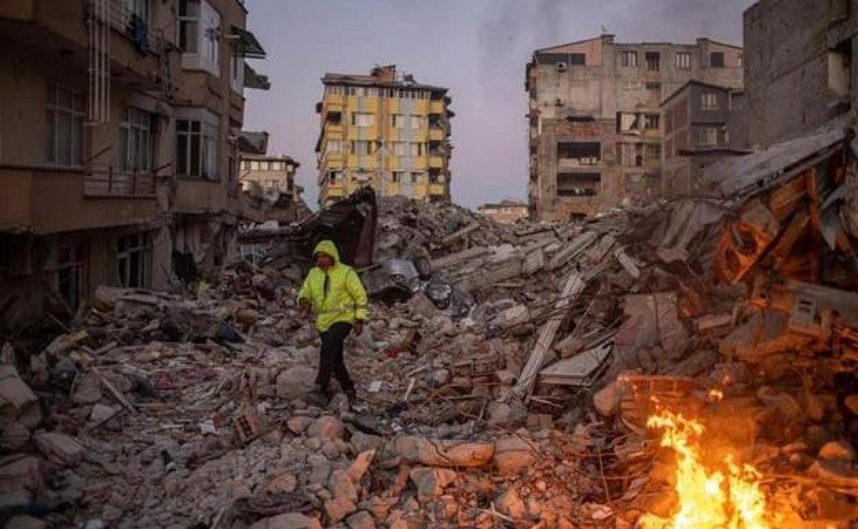 Un hombre camina sobre los escombros de los edificios derrumbados tras el potente terremoto en la localidad turca de Hatay