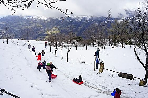 Adultos y niños disfrutan de la nieve en un paraje del Barranco del Poqueira, en la Alpujarra granadina, en una imagen de 2021.