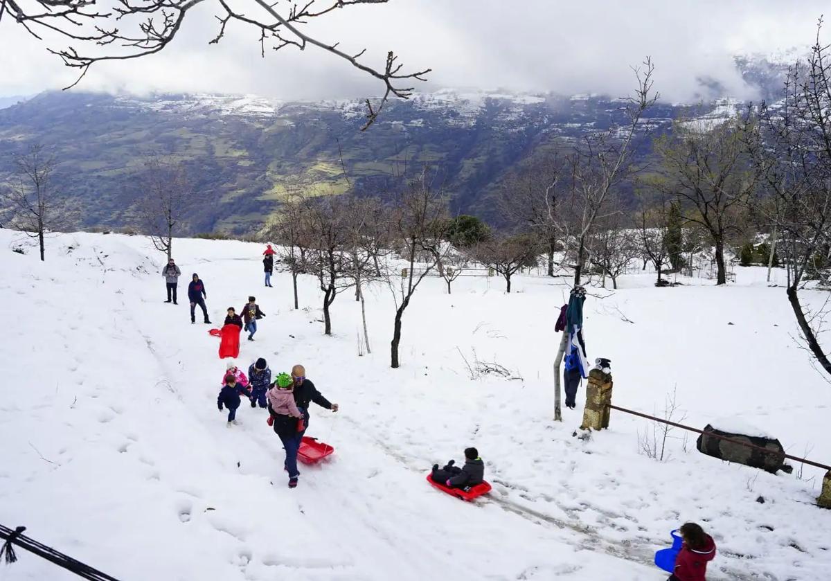 Adultos y niños disfrutan de la nieve en un paraje del Barranco del Poqueira, en la Alpujarra granadina, en una imagen de 2021.