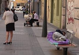 Imagen de archivo de una persona durmiendo en un banco en Almería.