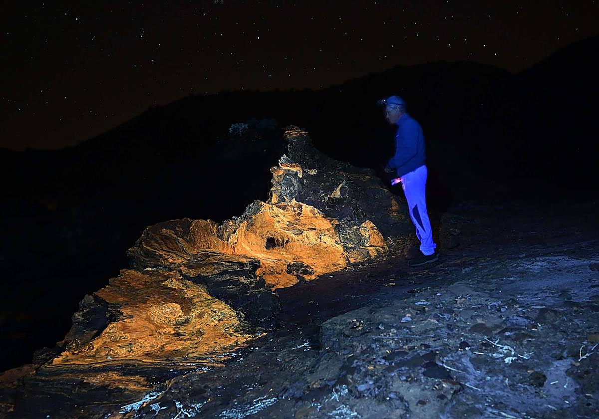 Un investigador de la UAL aplica luz ultravioleta a una roca de travertinos en Tabernas.