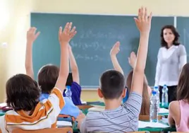 Alumnos levantan la mano en una clase.