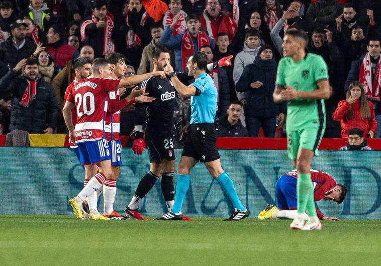 Los jugadores del Granada reclaman al árbitro.