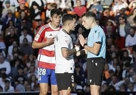 García Verdura dialoga con Hugo Duro tras señalar el penalti de Raúl Torrente, aún alucinado.