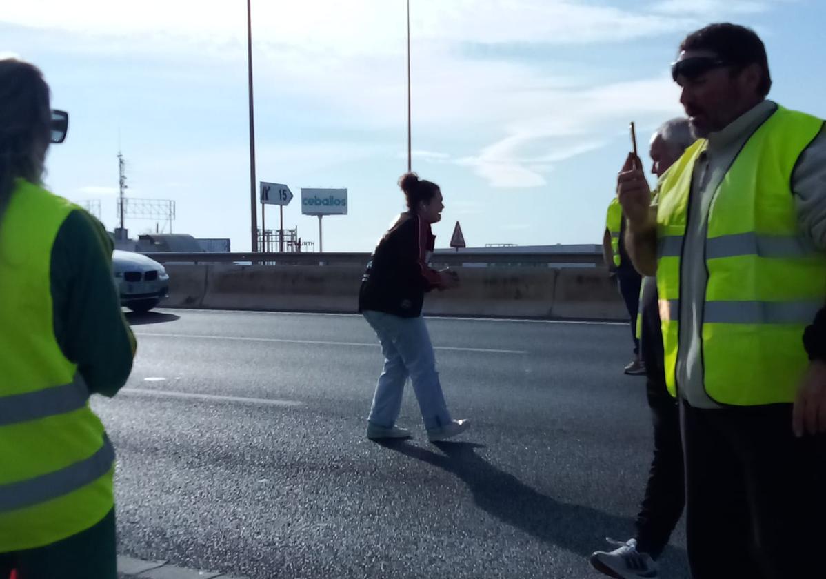 La estudiante pidiendo a los agricultores que la dejen pasar.