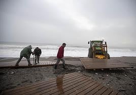 Operarios arreglan los destrozos causados por el temporal en Playa Granada.
