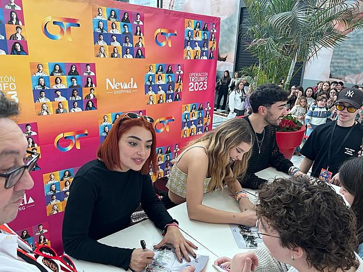 Violeta, Denna y Álex Márquez firman autógrafos a sus fans en el centro comercial Nevada.