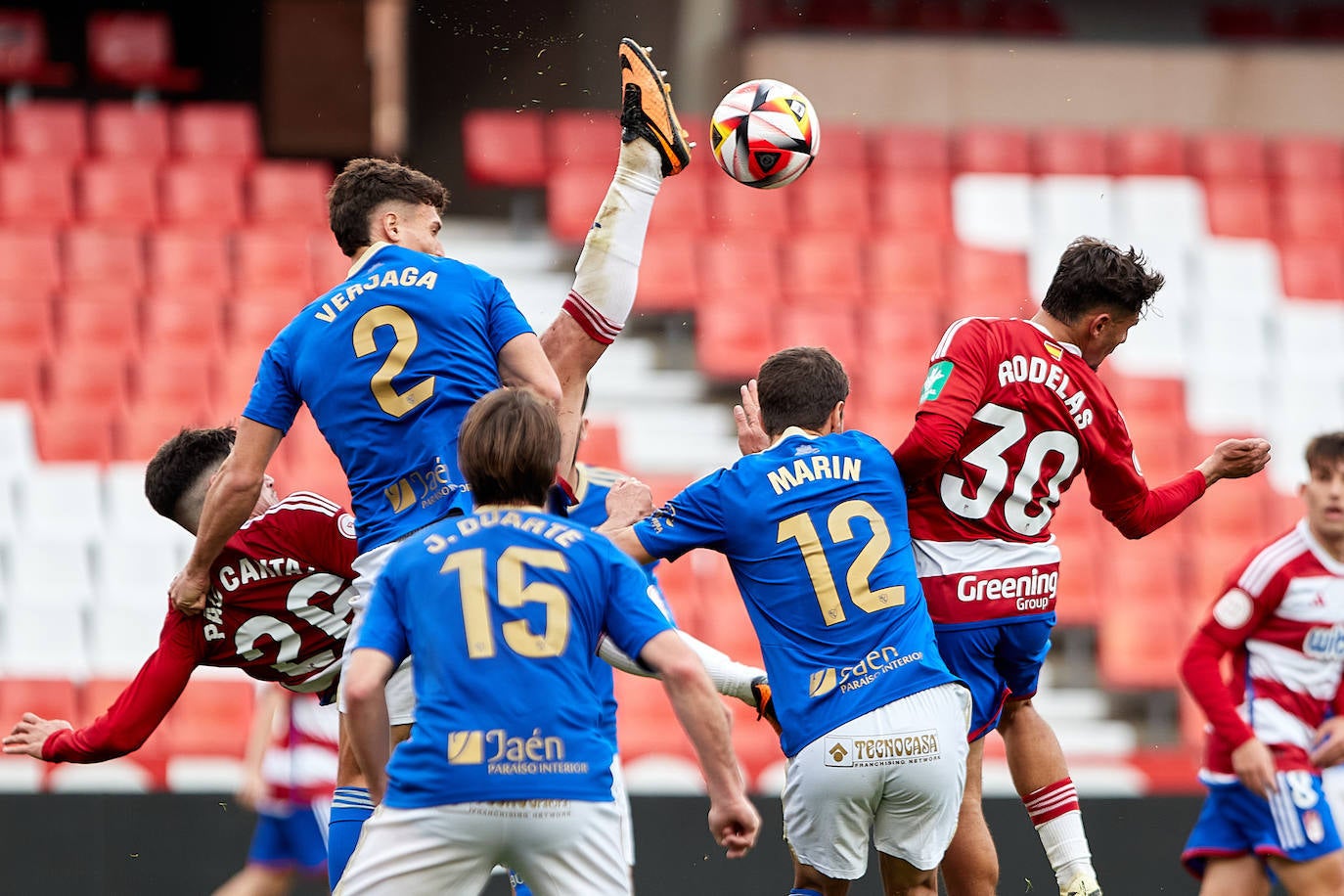 Jugadores azulillos disputan un balón al jugador granadino.