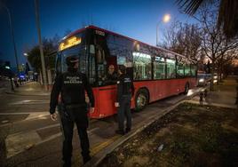 Dos agentes de la Policía Local conversan con un conductor del transporte público de Granada en el distrito Norte a la caída de la noche del lunes.