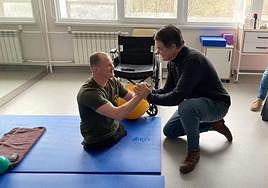 Carlos Rojas estrecha las manos de un soldado ucraniano que perdió las piernas en combate.