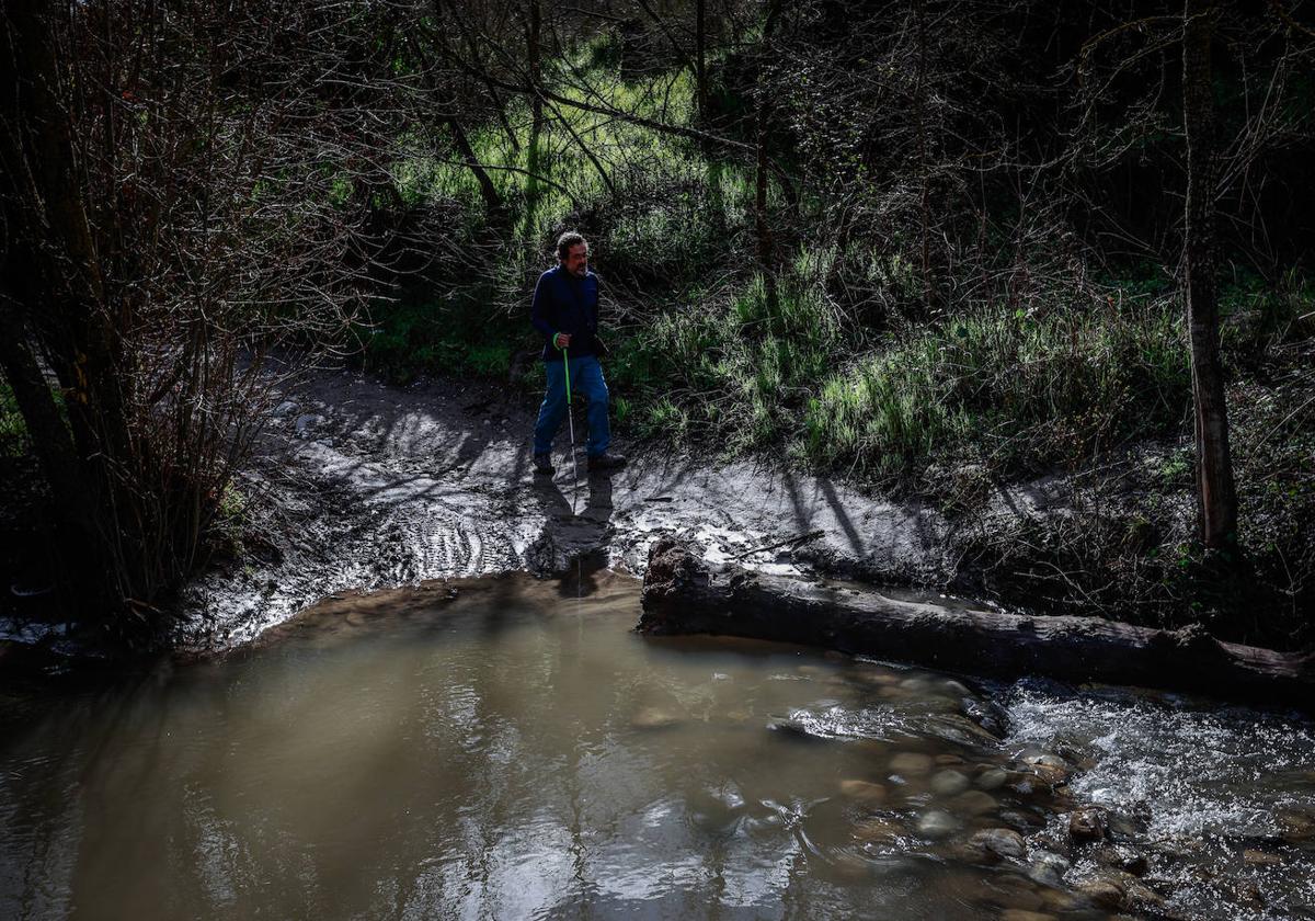 Un senderista se dispone a vadear el río Darro.