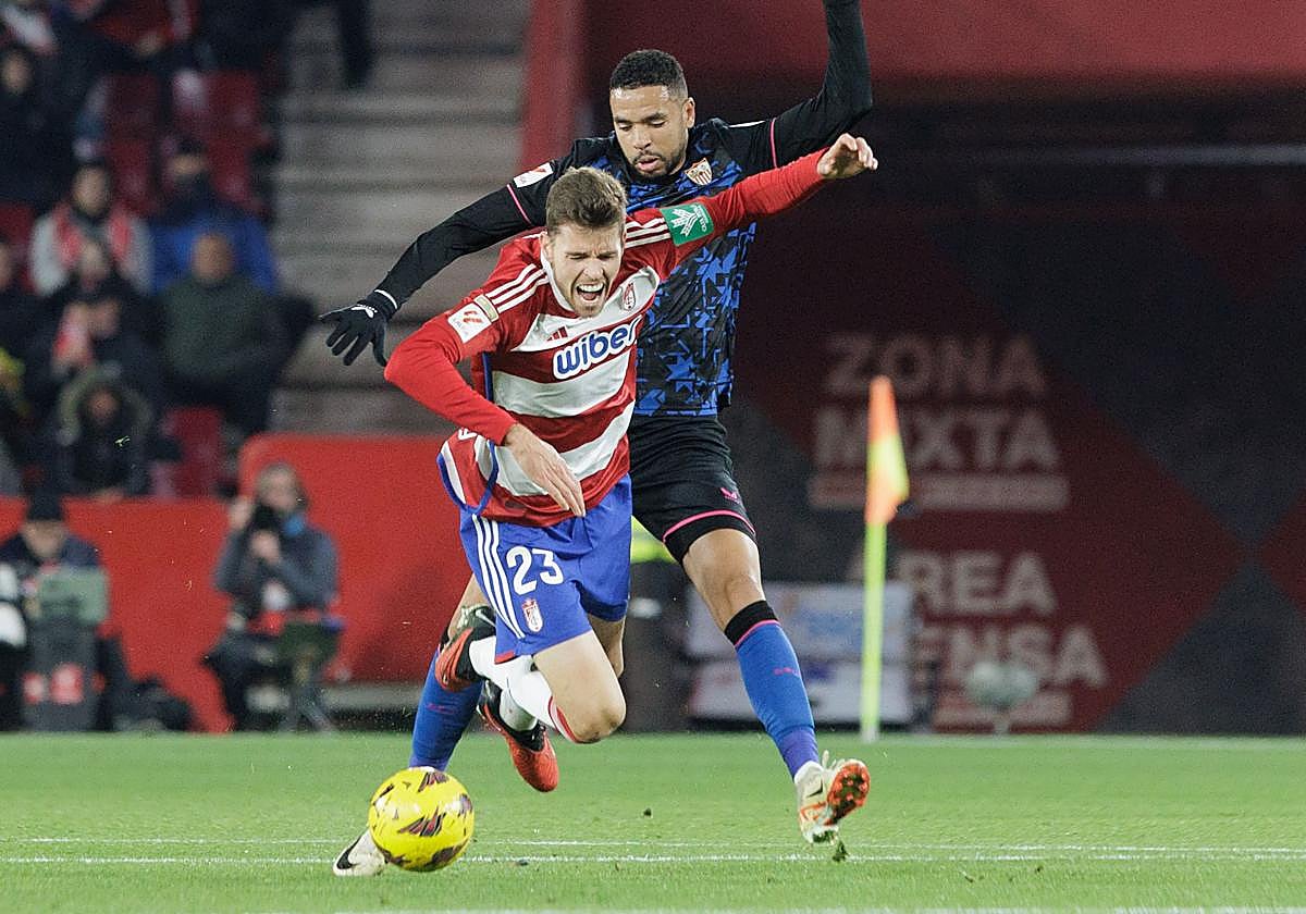 Gerard Gumbau recibe una carga de En-Nesyri durante el derbi con el Sevilla en Los Cármenes.