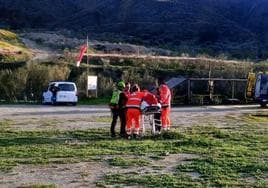 Profesionales sanitarios y miembros del Greim asistiendo al herido en la zona de aterrizaje de Cenes.