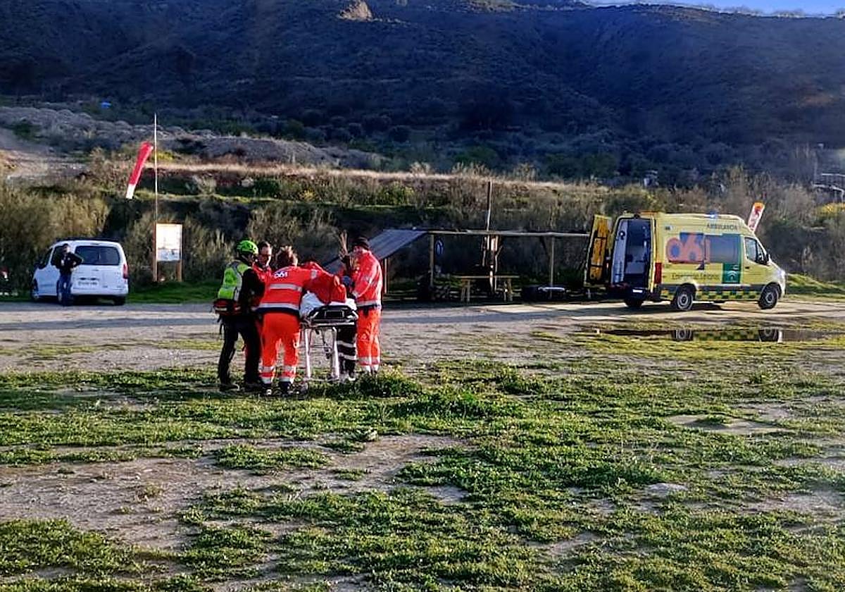 Profesionales sanitarios y miembros del Greim asistiendo al herido en la zona de aterrizaje de Cenes.