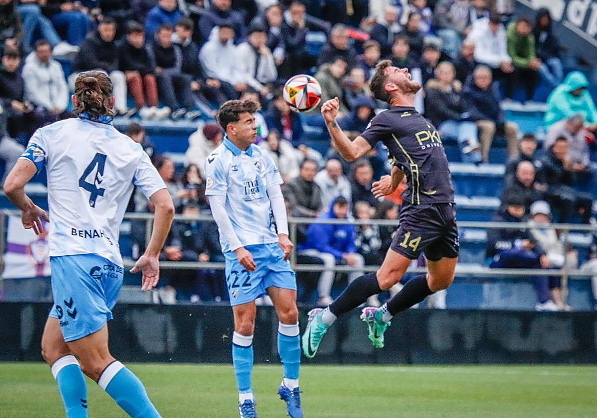 El local, Santaella, y el delantero jienense, Carlos Fernández, pugnan por el esférico.