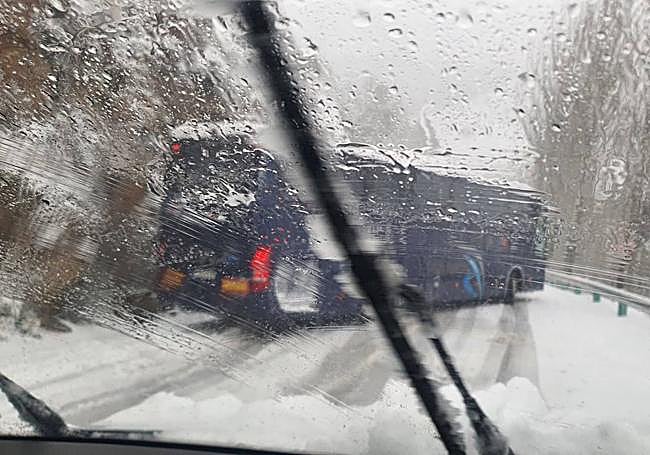 Autobús atravesado en la calzada de la carretera A-395 este sábado.