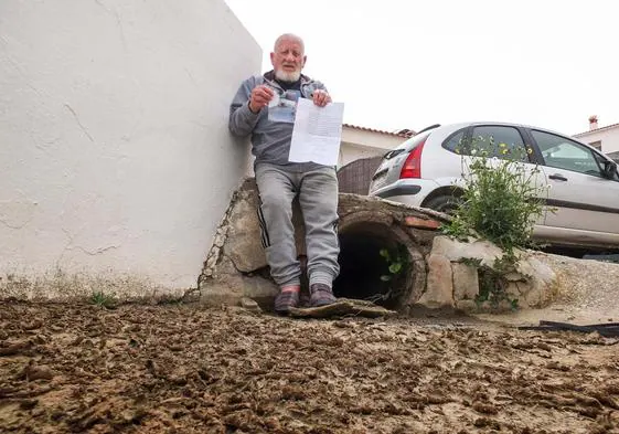 Francisco, vecino de Benalúa, posa con la carta y la fotografía que envió a IDEAL junto a la tubería que inunda la entrada de su casa.