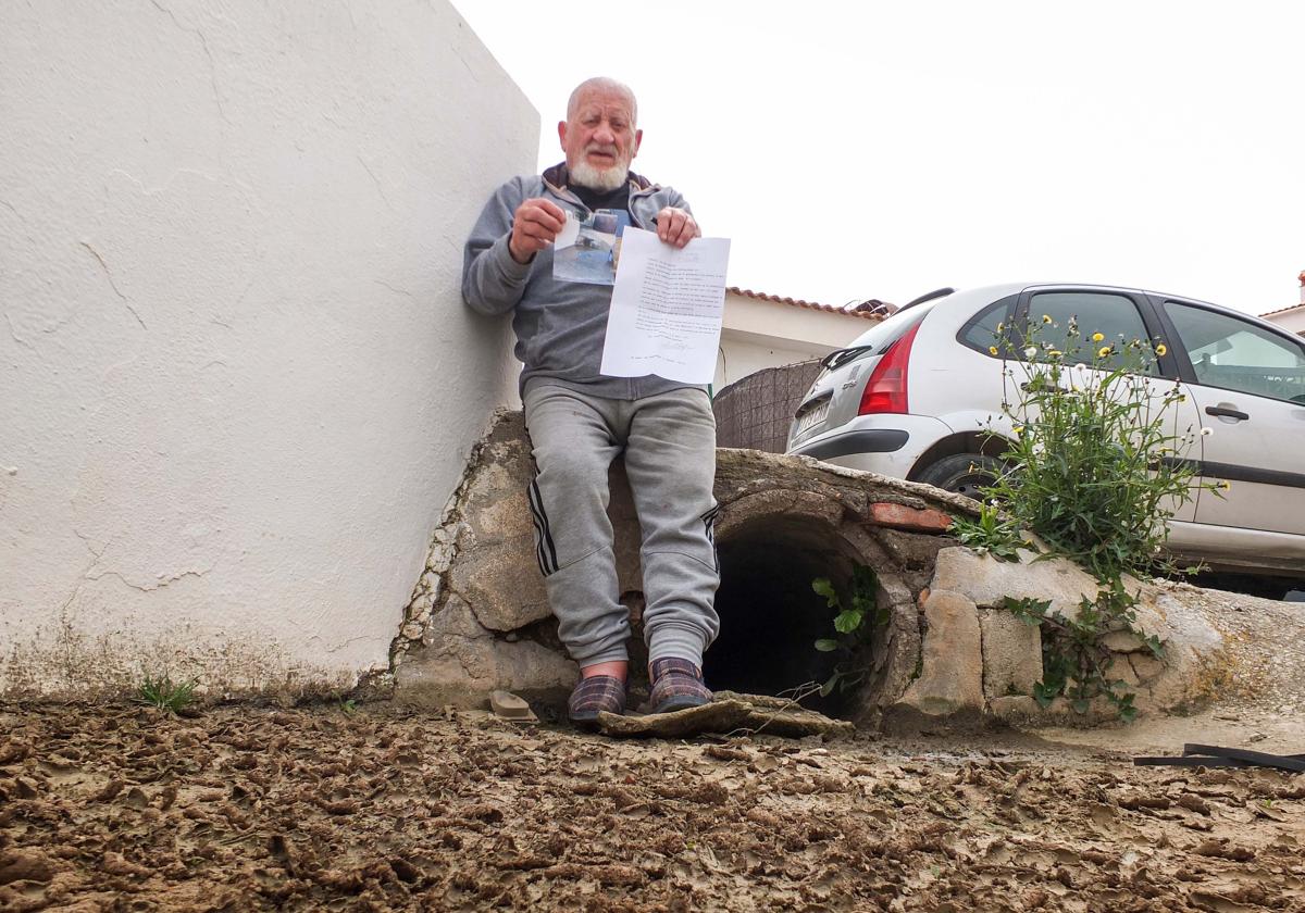 Francisco, vecino de Benalúa, posa con la carta y la fotografía que envió a IDEAL junto a la tubería que inunda la entrada de su casa.