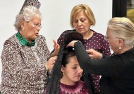 Las 'maestras' del taller colocan una mantilla a una gadorense.