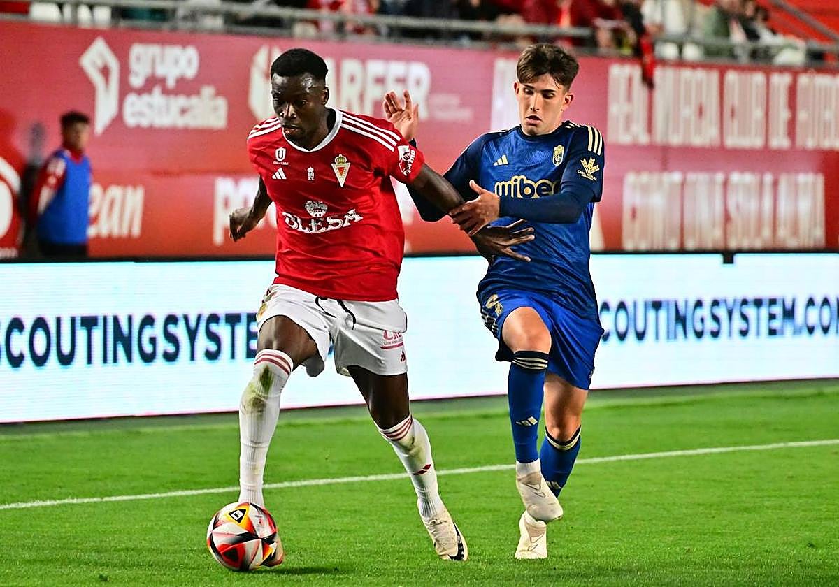 Sabit protege el balón ante la presión de Juanma.