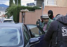 Agentes de la Guardia Civil sacan al detenido de su bloque de pisos.